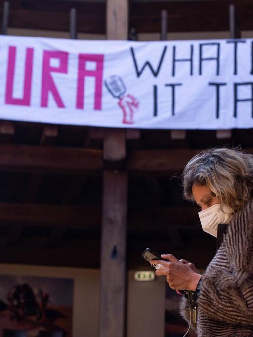 Eine Mitarbeiterin des pandemiebedingt geschlossenen Globe-Theaters in Rom steht vor einem Plakat mit dem Schriftzug: "Cultura - Whatever it takes".