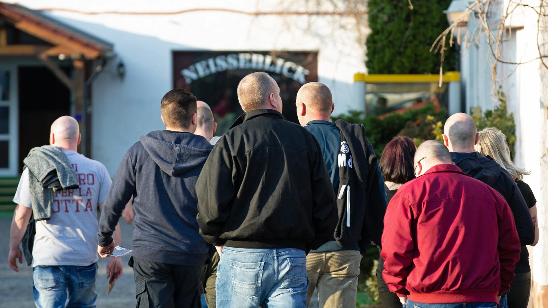 Mehrere Männer gehen in Ostritz auf das Hotel Neißeblick zu. Mehrere Männer gehen in Ostritz auf das Hotel Neißeblick zu.