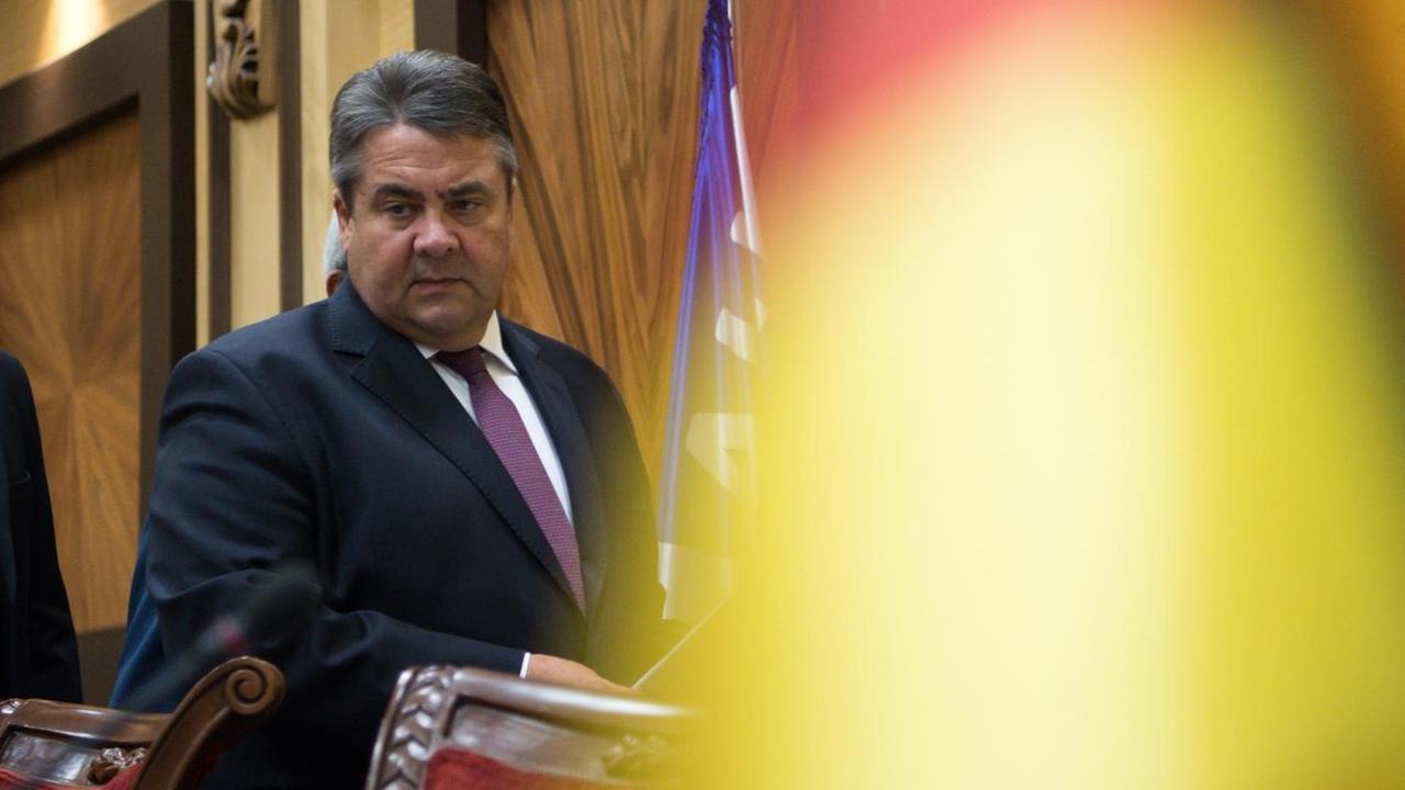 Bundeswirtschaftsminister Sigmar Gabriel betritt einen getäfelten Raum, vor ihm (unscharf) eine deutsche Flagge. Bundeswirtschaftsminister Sigmar Gabriel betritt einen getäfelten Raum, vor ihm (unscharf) eine deutsche Flagge.