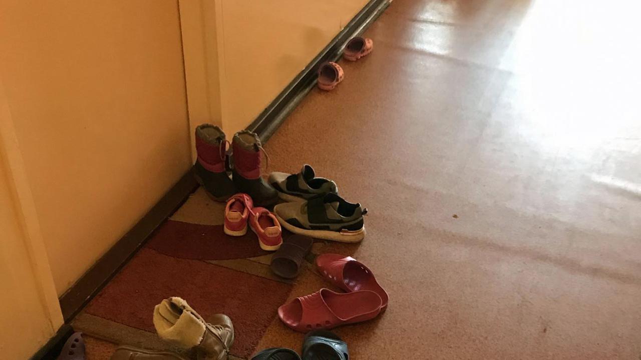 In einem Flur liegen Kinderschuhe auf dem Boden. In einem Flur liegen Kinderschuhe auf dem Boden.