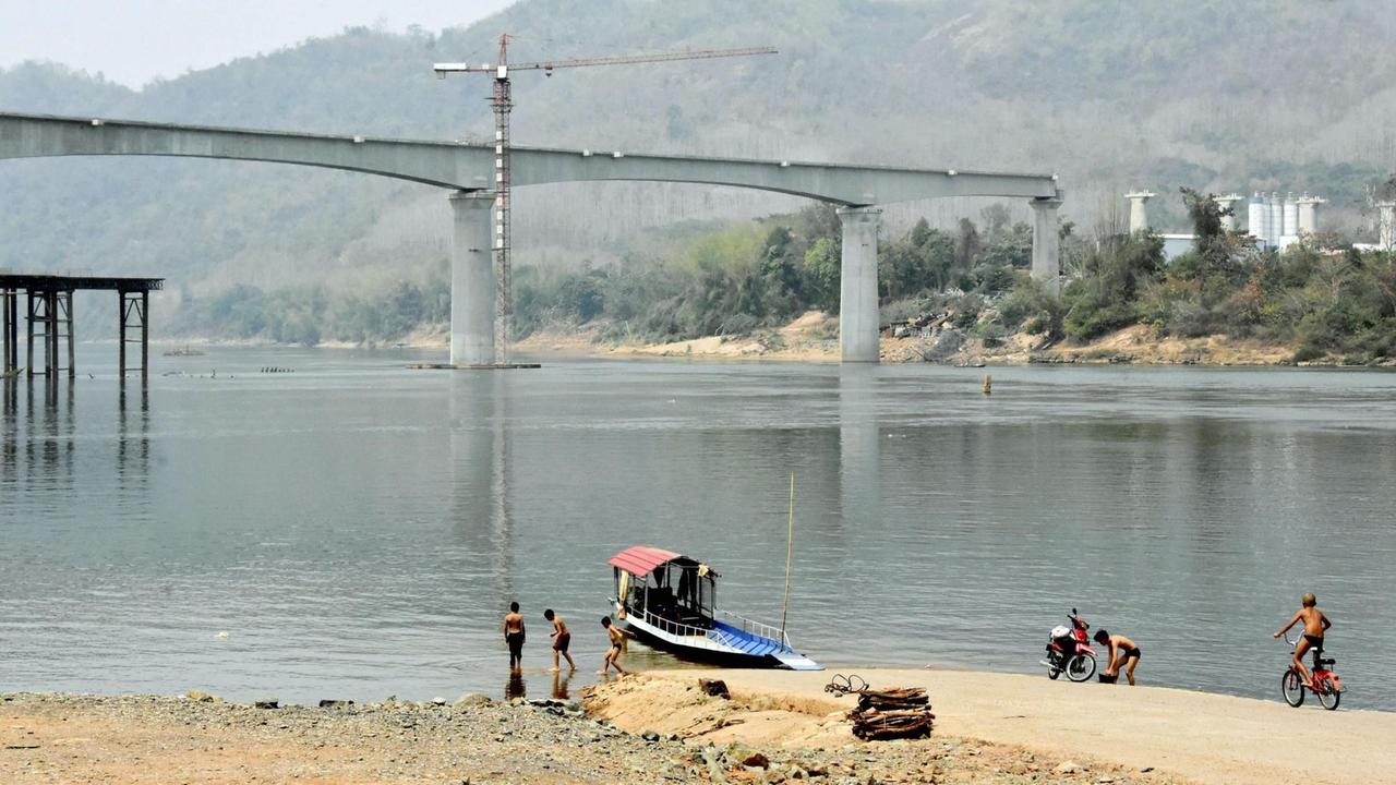 Blick auf die im Bau befindliche Eisenbahnbrücke über den Mekong.
Blick auf die im Bau befindliche Eisenbahnbrücke über den Mekong.