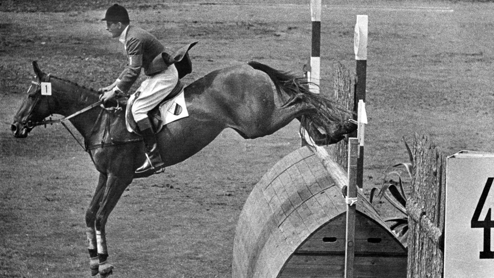 ARCHIV - 17.06.1956, Schweden, Stockholm: Springreiter Hans Günter Winkler auf seiner «Wunderstute» Halla beim Jagdspringen während der Olympischen Spiele in Stockholm. Mit dem fehlerfrei Ritt sichert er sich den Olympiasieg. (Zu "Springreiter Hans-Günter Winkler gestorben" vom 09.07.2018) Foto: dpa +++ dpa-Bildfunk +++ ARCHIV - 17.06.1956, Schweden, Stockholm: Springreiter Hans Günter Winkler auf seiner «Wunderstute» Halla beim Jagdspringen während der Olympischen Spiele in Stockholm. Mit dem fehlerfrei Ritt sichert er sich den Olympiasieg. (Zu "Springreiter Hans-Günter Winkler gestorben" vom 09.07.2018) Foto: dpa +++ dpa-Bildfunk +++