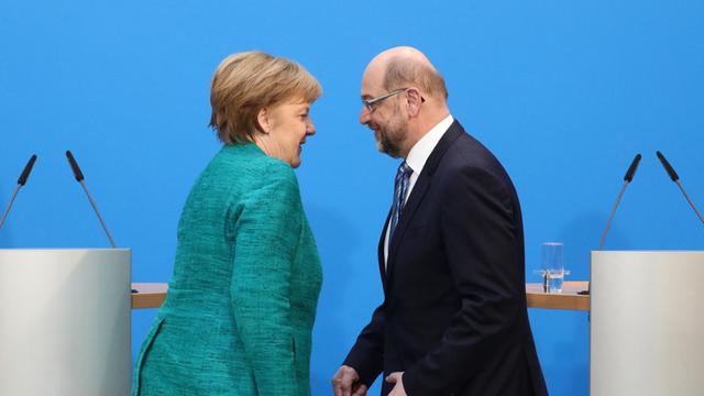 Bundeskanzlerin Angela Merkel (CDU) und der SPD-Vorsitzende Martin Schulz kommen nach den Koalitionsverhandlungen von CDU, CSU und SPD auf einer Pressekonferenz auf die Bühne.