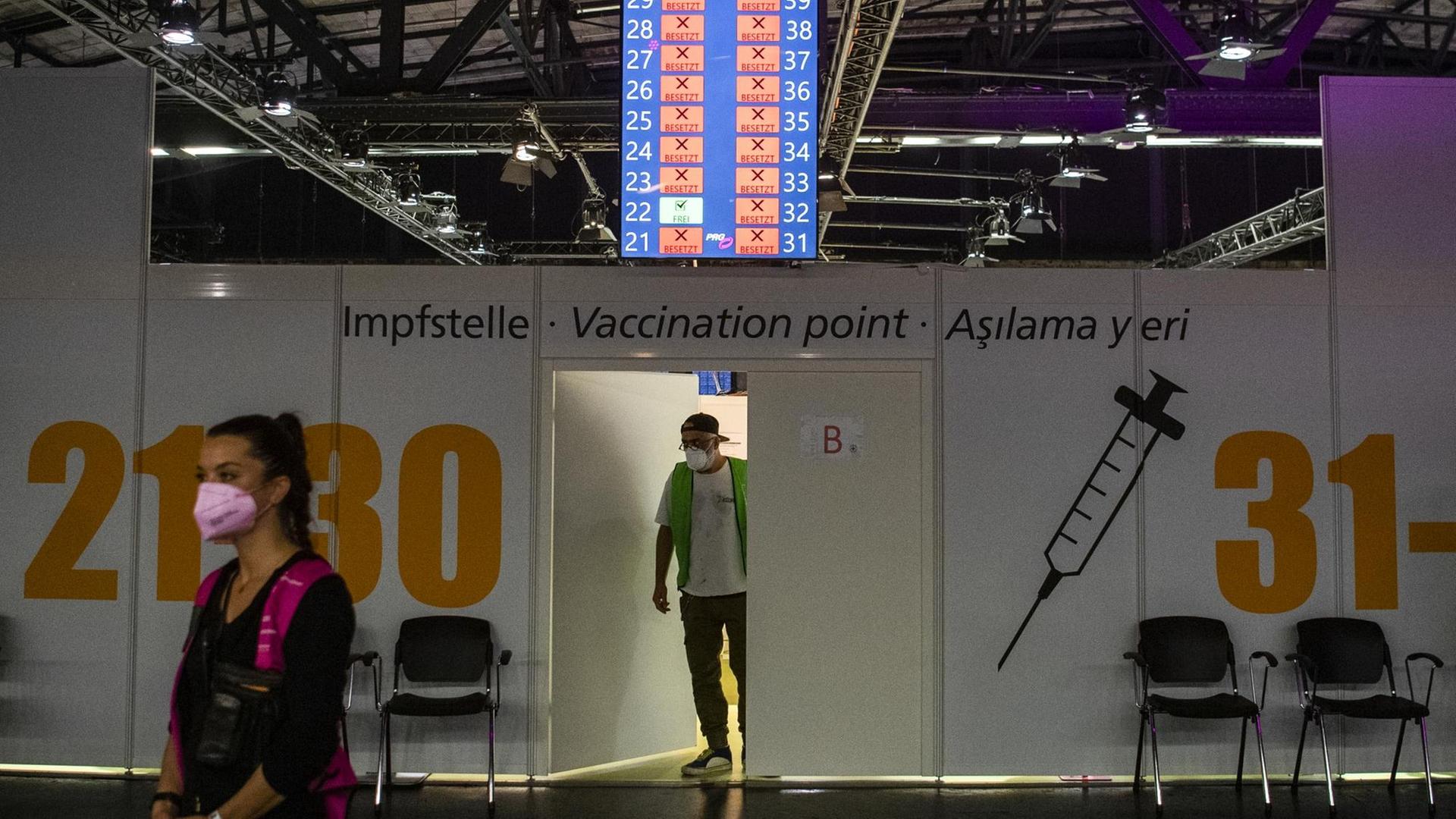 Ein Mitarbeiter geht bei der 1. Langen Nacht des Impfens im Impfzentrum Arena in Treptow aus einer Tür. Bei der ersten "Langen Nacht des Impfens" hat es am Montagabend großen Andrang gegeben. Ein Mitarbeiter geht bei der 1. Langen Nacht des Impfens im Impfzentrum Arena in Treptow aus einer Tür. Bei der ersten "Langen Nacht des Impfens" hat es am Montagabend großen Andrang gegeben.