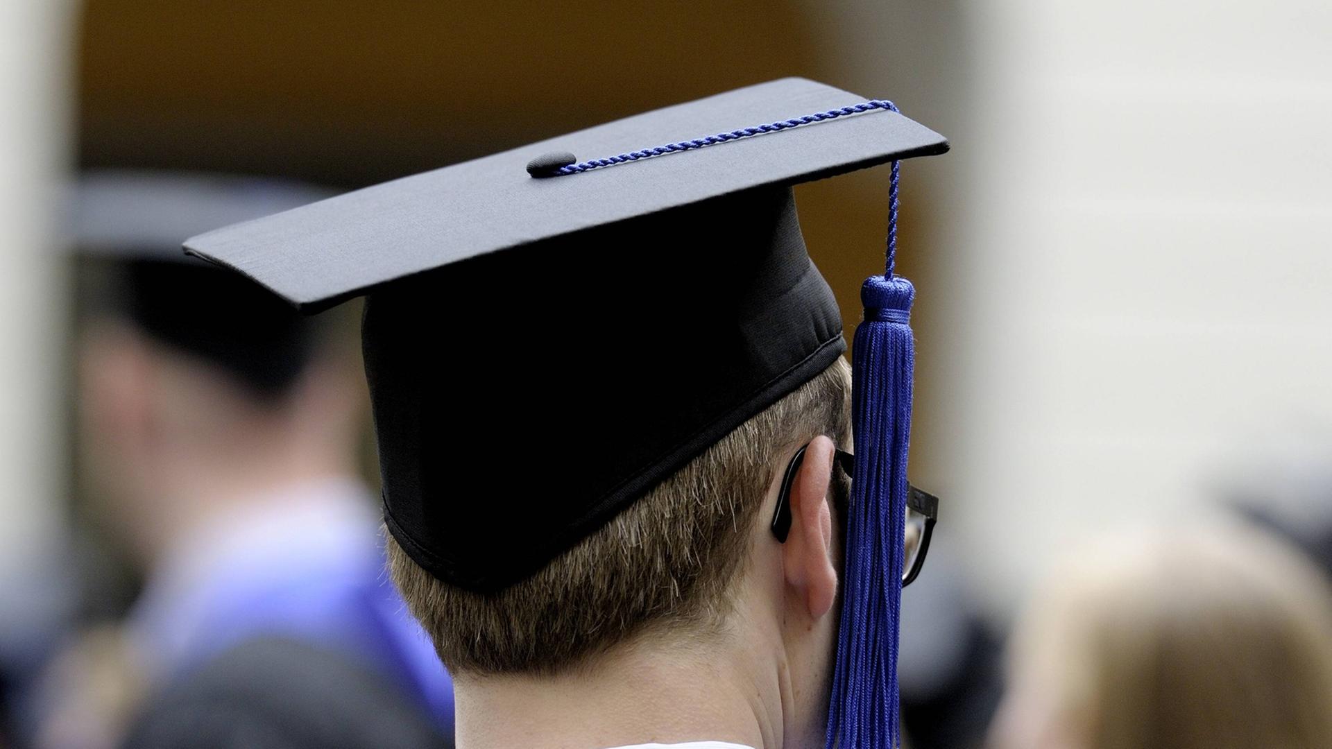Ein Student der Universität Bonn in Talar und Barett / Doktorhut während der Abschlussfeier Ein Student der Universität Bonn in Talar und Barett / Doktorhut während der Abschlussfeier