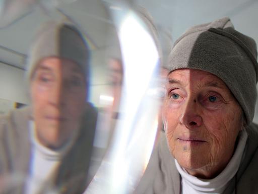 Die Künstlerin Mary Bauermeister betrachtet am Donnerstag (19.04.2012) in Bonn eines ihrer Kristall-Objekte.