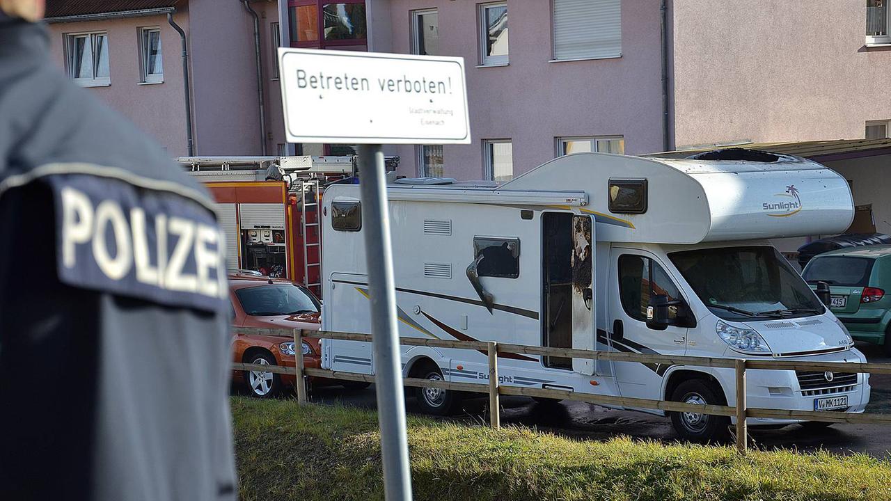 Ein Polizist steht am 04.11.2011 in Eisenach-Stregda vor einem qualmenden Wohnwagen, in dem zwei Leichen entdeckt wurden: die von Uwe Mundlos und Uwe Böhnhardt. Ein Polizist steht am 04.11.2011 in Eisenach-Stregda vor einem qualmenden Wohnwagen, in dem zwei Leichen entdeckt wurden: die von Uwe Mundlos und Uwe Böhnhardt.