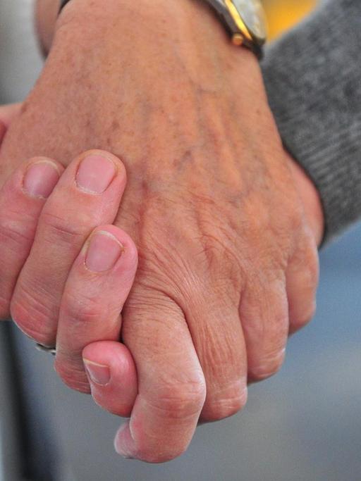 Die ehrenamtliche Helferin Ilse Danneil hält im Hospiz St. Martin in Stuttgart die Hand einer Frau.
