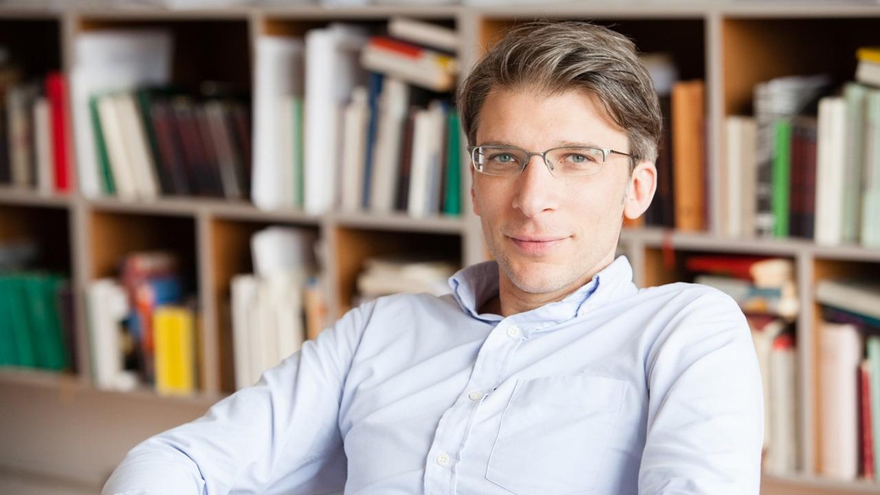 Porträt: Armen Avanessian vor einer Bücherwand, aufgenommen 2014 Porträt: Armen Avanessian vor einer Bücherwand, aufgenommen 2014
