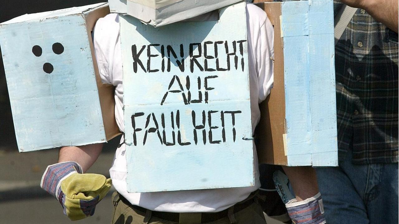 Ein Demonstrant nimmt am 5.9.2002 in Berlin in einem selbstgefertigten Roboterkostüm mit der Aufschrift "Kein Recht auf Faulheit" an einer Kundgebung von Arbeitslosen teil. Auch im August 2002 hat die Zahl der Arbeitslosen die Vier-Millionen-Grenze überschritten.