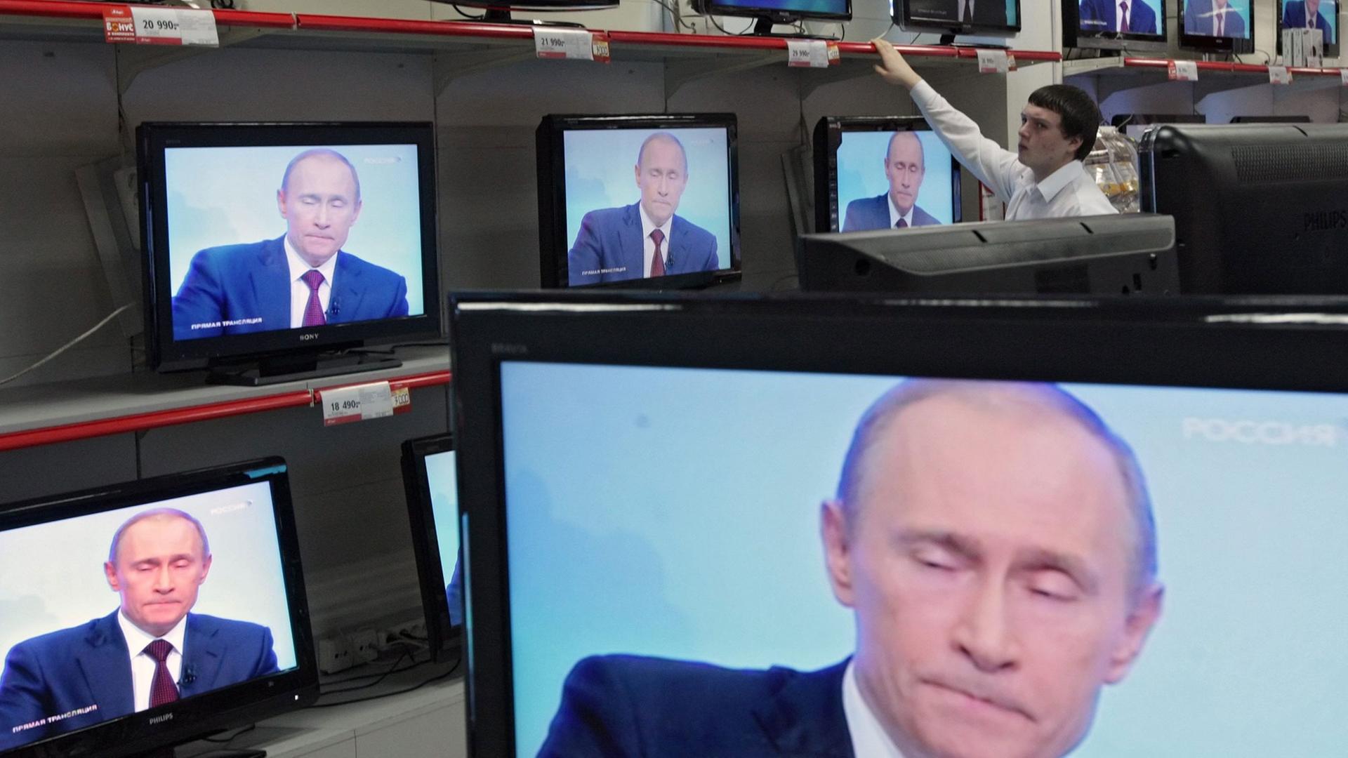 Wladimir Putin ist in einem Geschäft auf diversen TV-Bildschirmen zu sehen. Wladimir Putin ist in einem Geschäft auf diversen TV-Bildschirmen zu sehen.