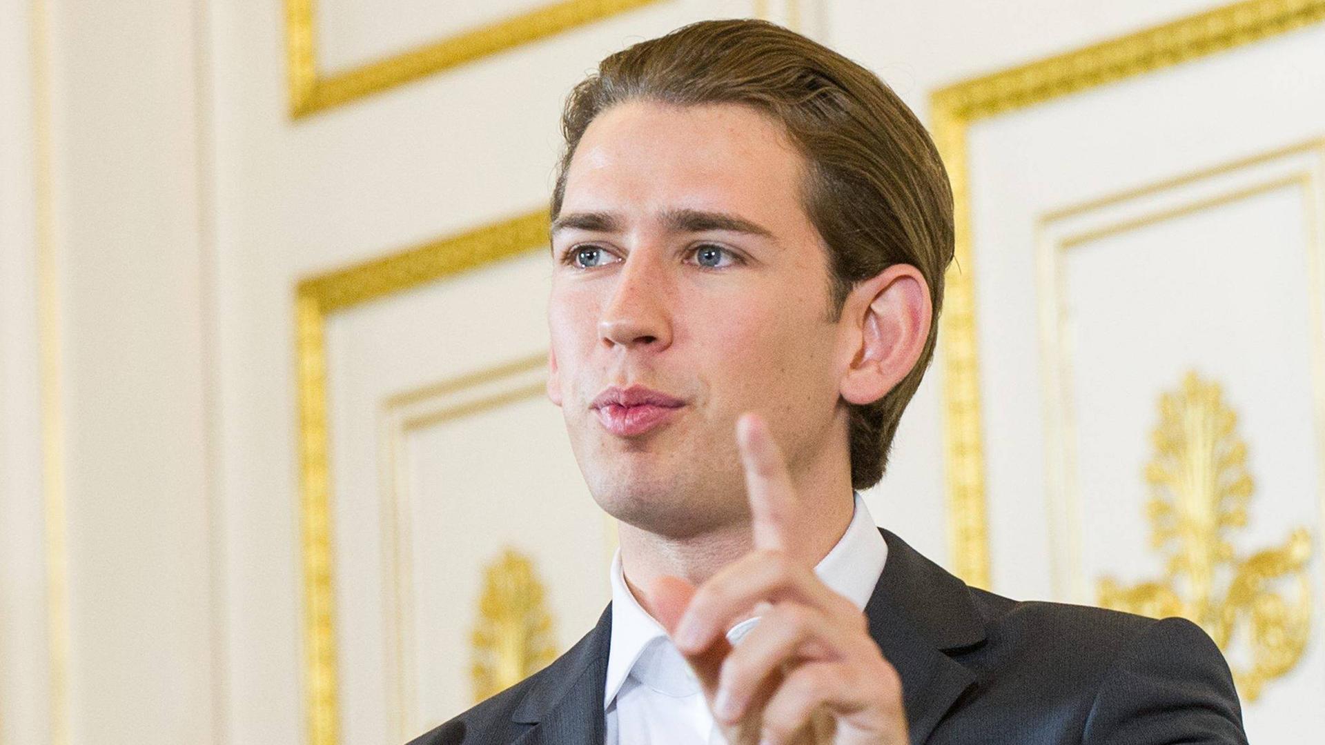 Österreichs Außenminister Sebastian Kurz mit erhobenem Zeigefinger vor einer gold-weißen Tür Österreichs Außenminister Sebastian Kurz mit erhobenem Zeigefinger vor einer gold-weißen Tür