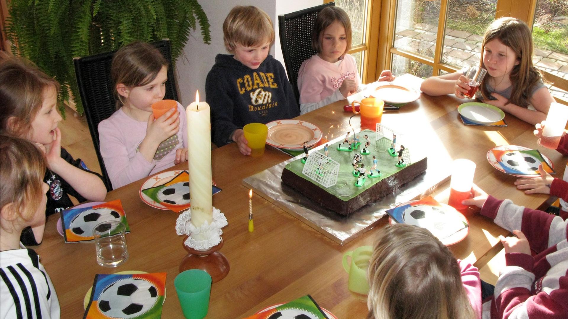 tellerKinder feiern einen Kindergeburtstag an einem bunt gedeckten Tisch. tellerKinder feiern einen Kindergeburtstag an einem bunt gedeckten Tisch.
