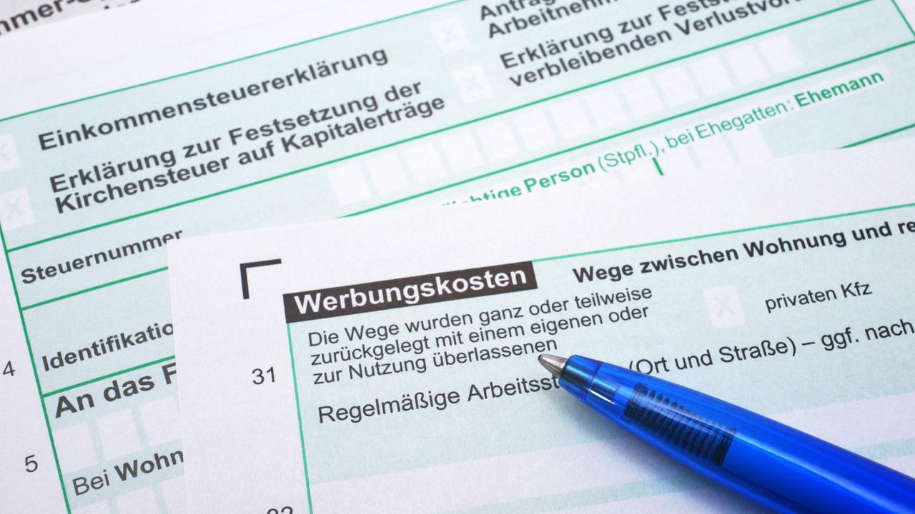 Auf dem Bogen für eine Steuerklärung liegt ein blauer Kugelschreiber. Auf dem Bogen für eine Steuerklärung liegt ein blauer Kugelschreiber.