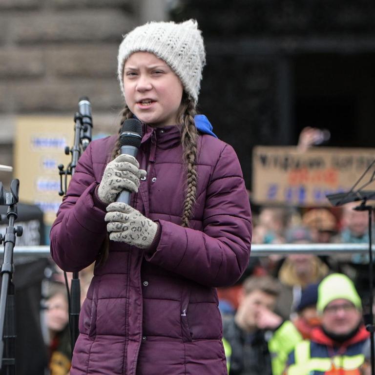 Klimaaktivistin Greta Thunberg am 1. März bei der Fridays For Future Demonstration in Hamburg. Ein Mädchen steht mit einem Mikrofon auf einer Bühne und spricht zu Demonstrierenden.