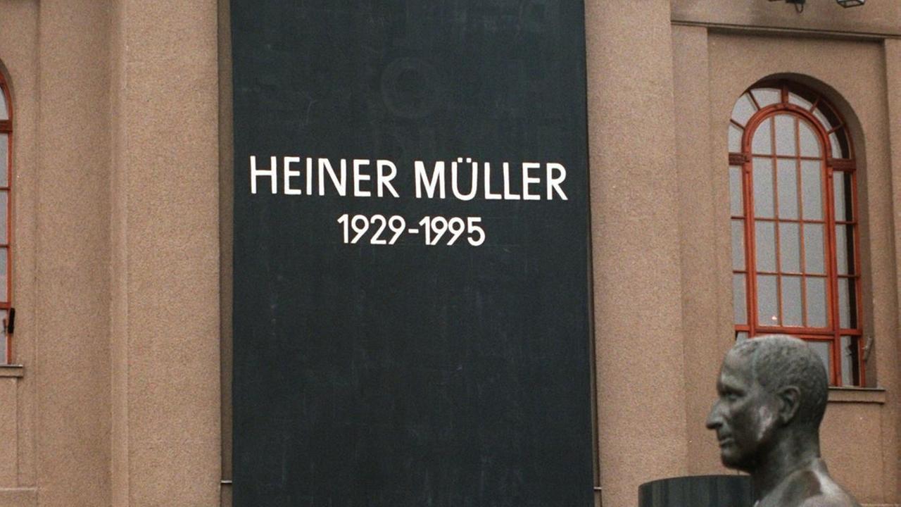 Ein Farbfoto zeigt, wie unter einer schwarzen Fahne Gäste der Tauerfeier für den Dramatiker Heiner Müller am 16.1.1996 das Gebäude des Berliner Ensembles, verlassen. im Vordergrund eine Plastik von Bertolt Brecht. 