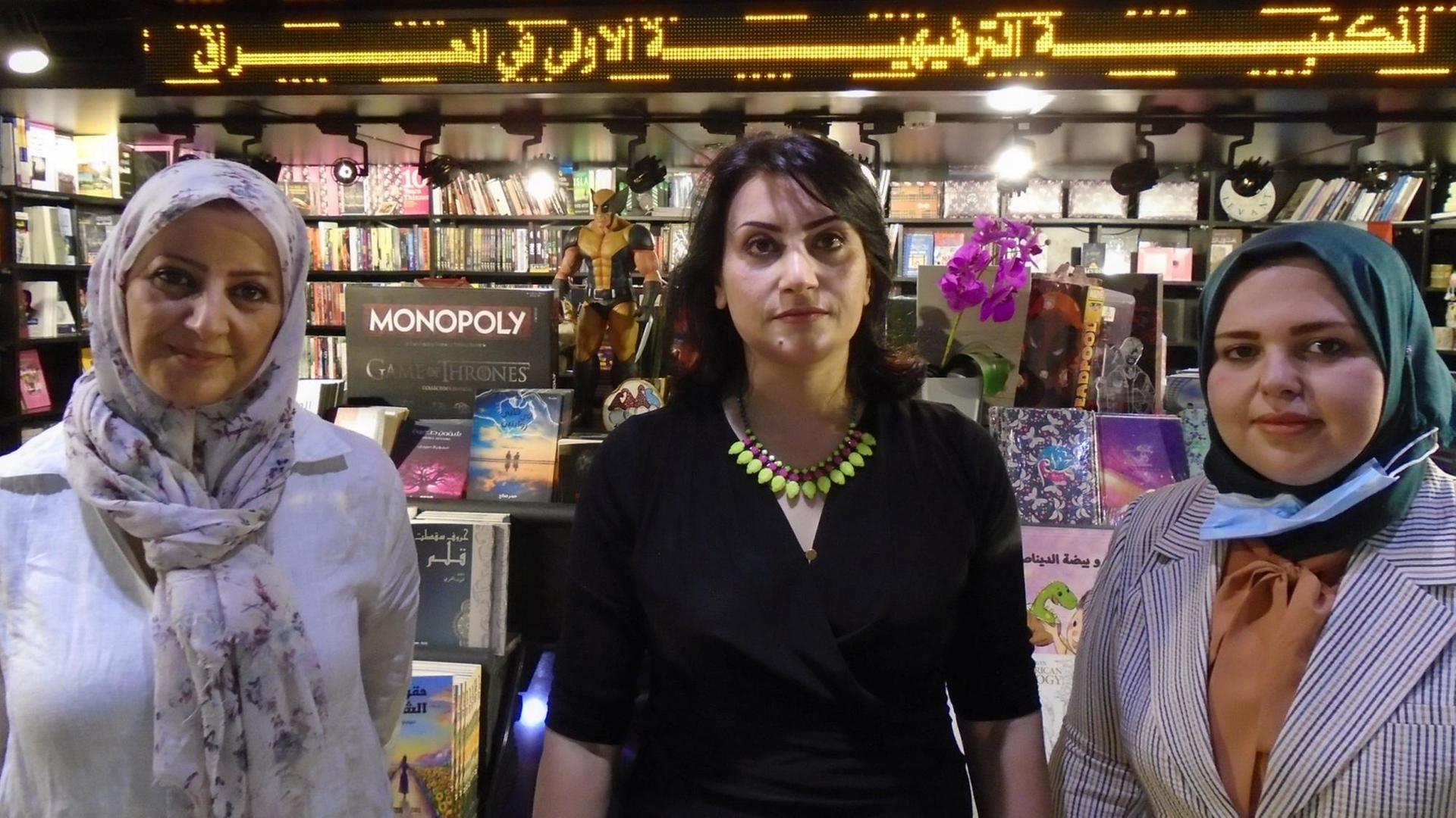 Drei Frauen stehen vor einem Buchladen Drei Frauen stehen vor einem Buchladen