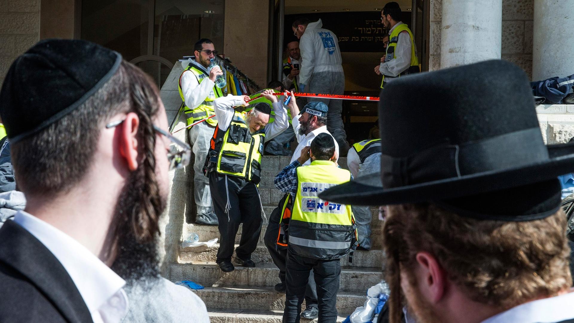 Zwei ultra-orthodoxe Juden blicken auf die Synagoge, in der vier Menschen bei einem Anschlag starben. Zwei ultra-orthodoxe Juden blicken auf die Synagoge, in der vier Menschen bei einem Anschlag starben.