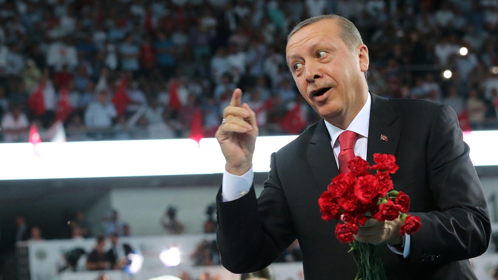 Recep Tayyip Erdogan wirft rote Blumen ins Publikum. Recep Tayyip Erdogan wirft rote Blumen ins Publikum.