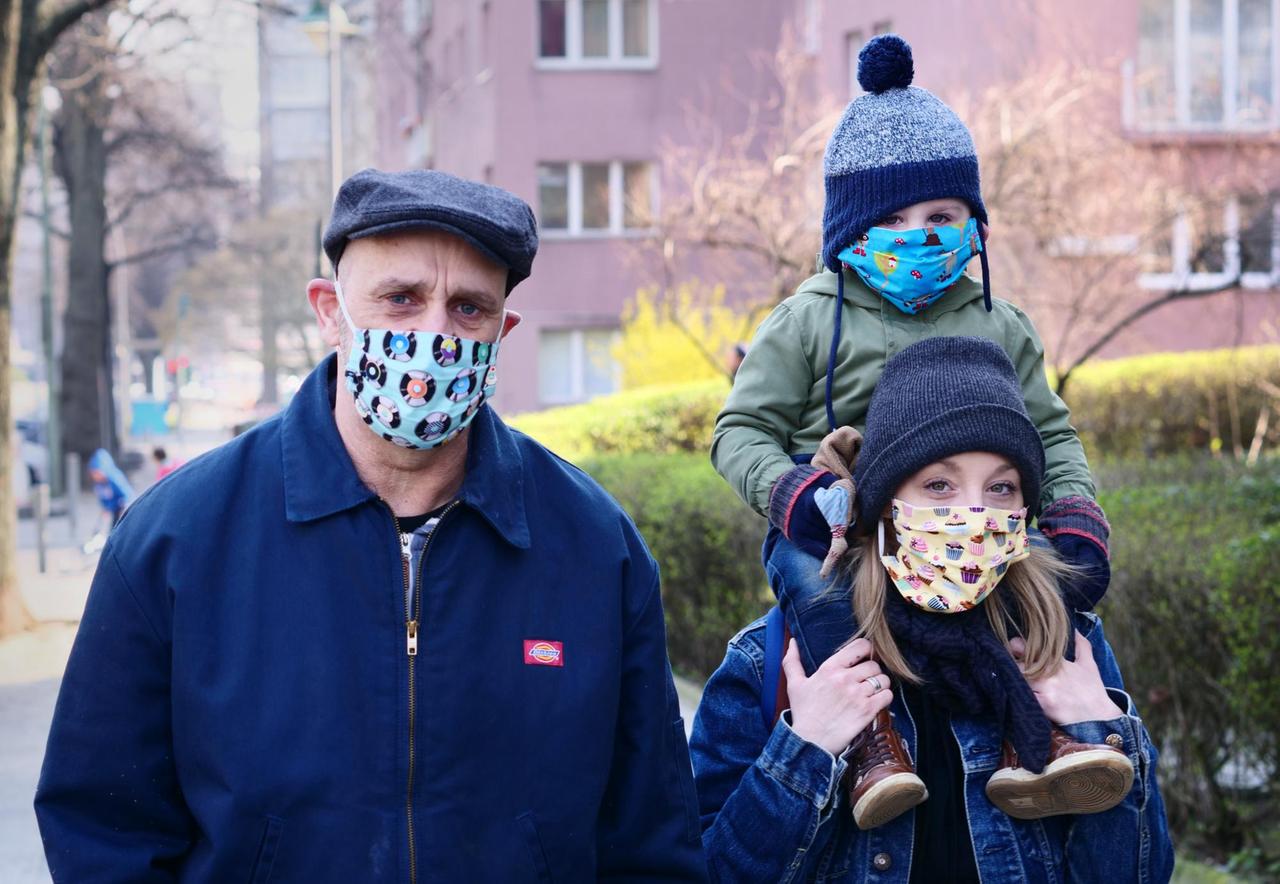 28.03.2022, Berlin: Eine Familie geht in Friedenau spazieren. Alle Familienmitglieder tragen dabei bunte Masken, als Schutz gegen das Coronavirus. Die Masken wurden von einer Freundin der Familie selbst genäht. Foto: Wolfram Steinberg/dpa | Verwendung weltweit