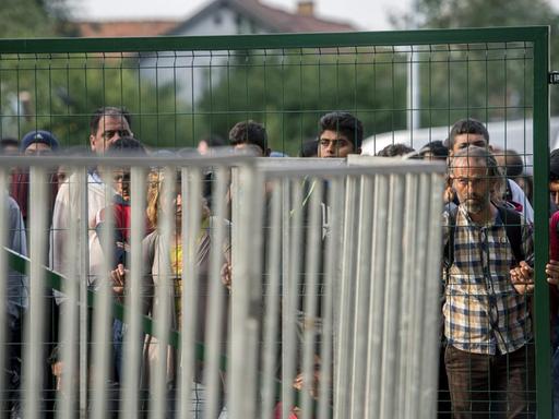 Flüchtlinge warten am Grenzzaun bei Röszke an der ungarisch-serbischen Grenze.