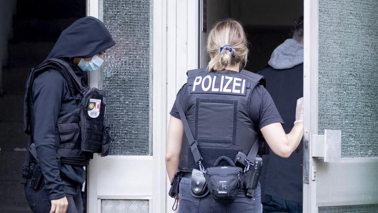 Polizisten gehen in ein Haus. Polizisten gehen in ein Haus.