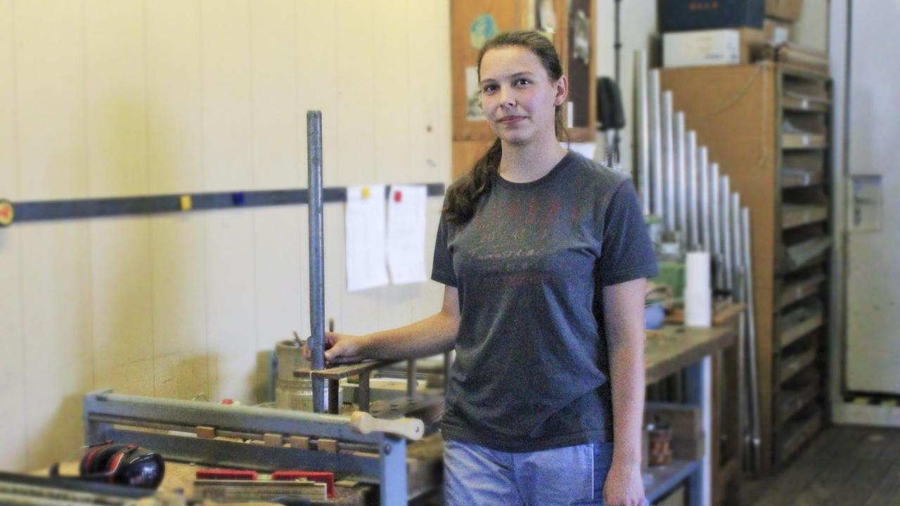 Annegret Pabst, angehende Orgelbauerin, steht in einer Orgelbauwerkstatt.