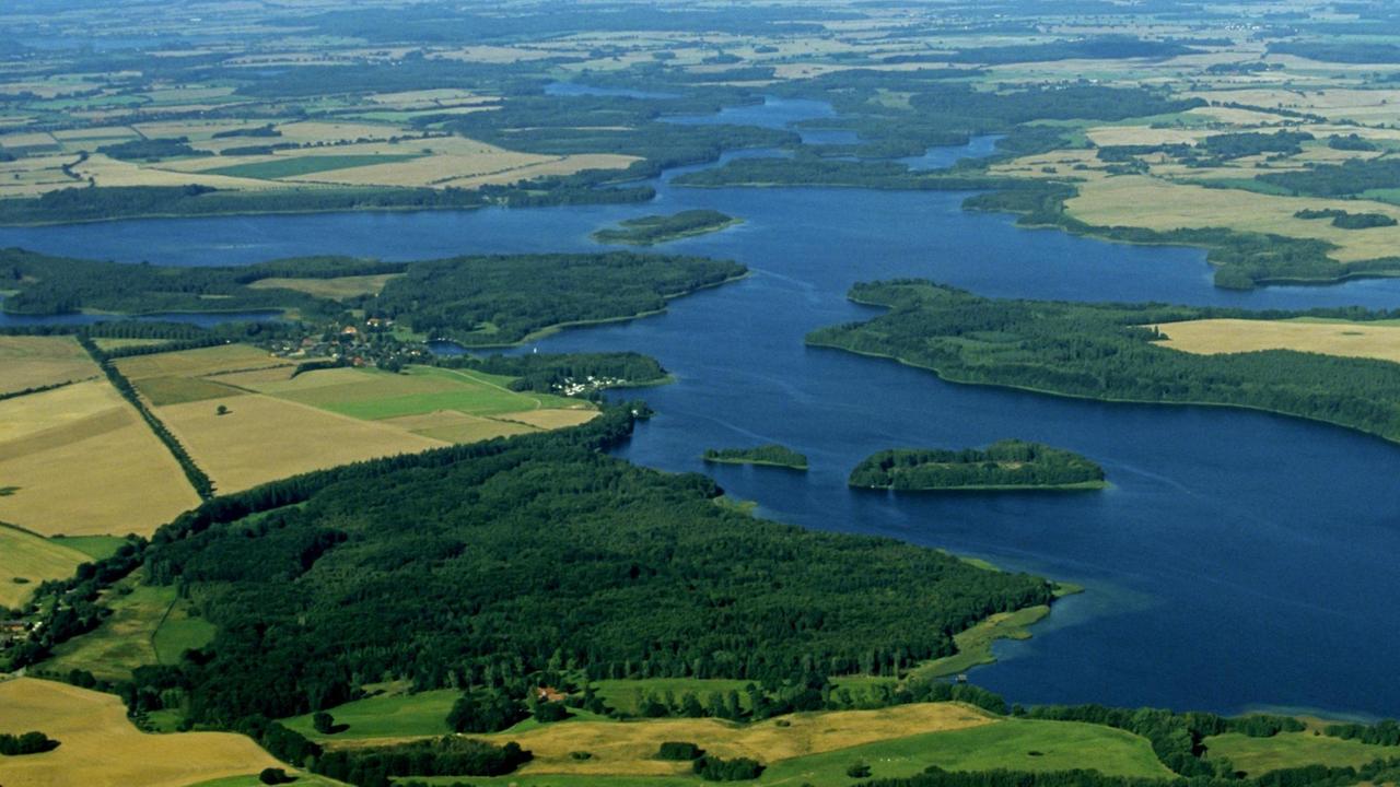 Schaalsee: Aus der Luft fotografiert. schaut man bei dieser Aufnahme auf die tiefblaue mäandernde Fläche des Sees, die in der Ferne in den Horizont übergeht, auf dunkelgrüne Wald- und auf strohgelbe Feldflächen.