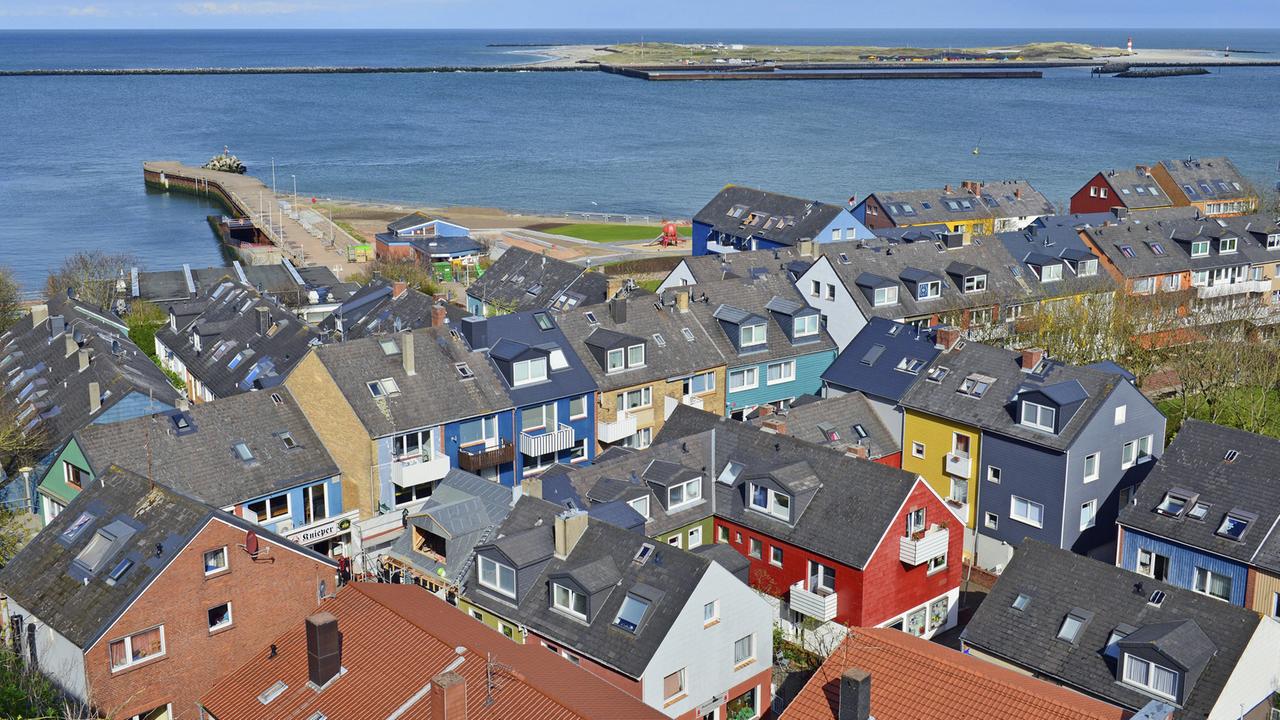 Viele bunte Häuser auf dem Unterland von Helgoland mit grauen Dächern und der Nordsee am Horizont Viele bunte Häuser auf dem Unterland von Helgoland mit grauen Dächern und der Nordsee am Horizont
