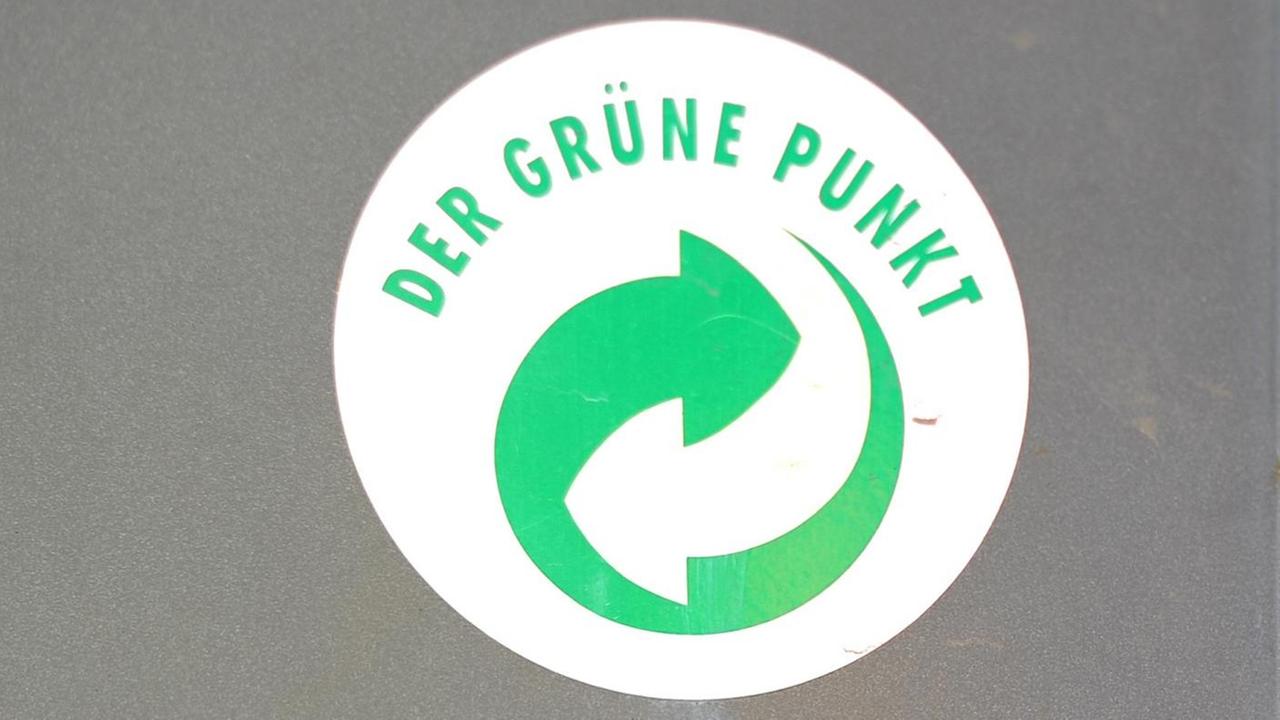 Ein Aufkleber mit dem Logo "Der Grüne Punkt" klebt auf einem Mülleimer.
Ein Aufkleber mit dem Logo "Der Grüne Punkt" klebt auf einem Mülleimer.
