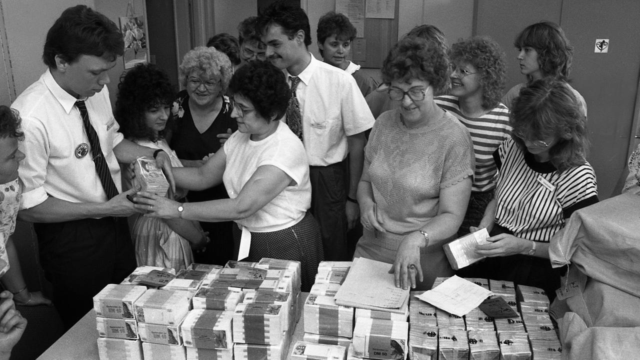 Mitarbeiter einer Sparkasse in Leipzig zahlen am 1. Juli 1990 Geld aus und tauschen die Konten der DDR-Bürger. Mitarbeiter einer Sparkasse in Leipzig zahlen am 1. Juli 1990 Geld aus und tauschen die Konten der DDR-Bürger.