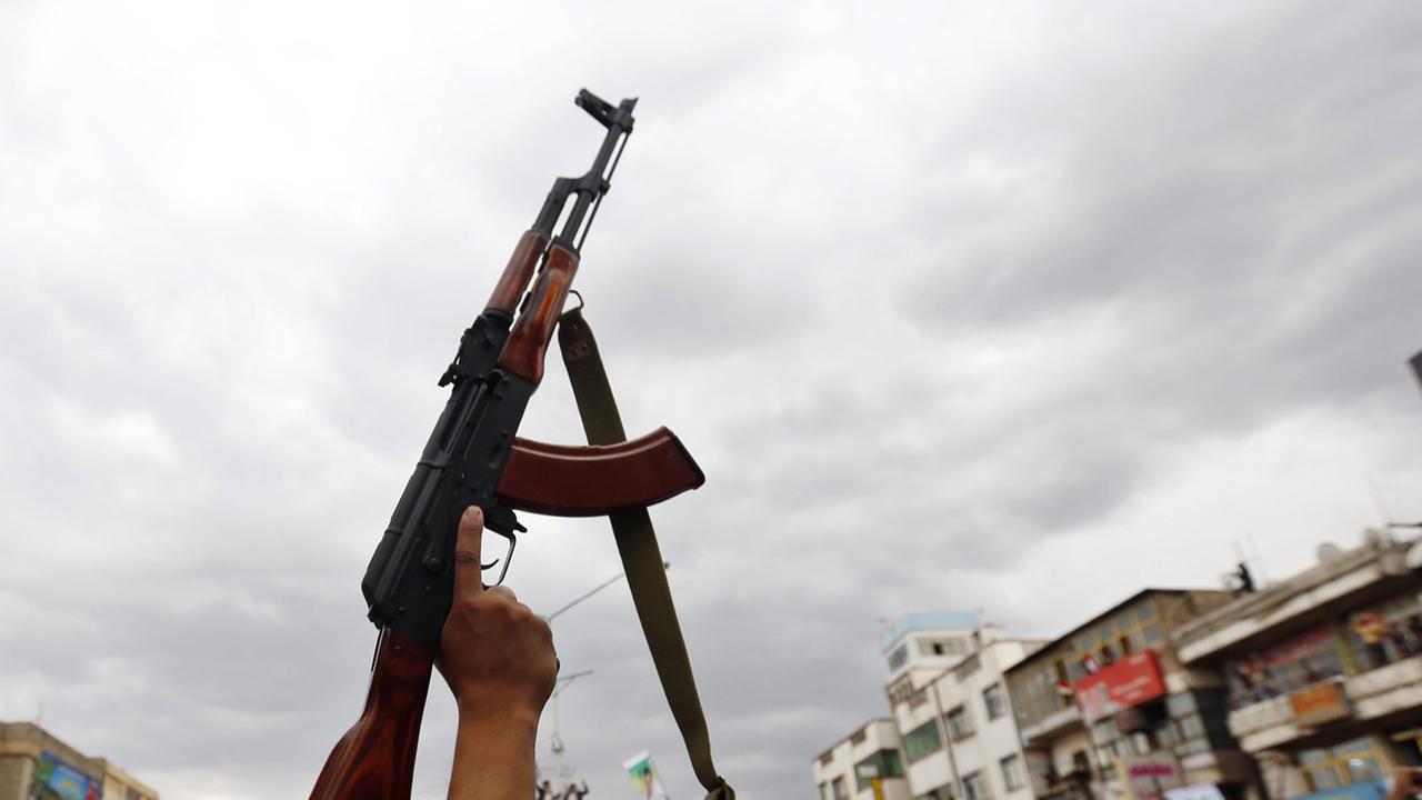 Ein Maschinengewehr wird von einer Hand gehalten. Ein Maschinengewehr wird von einer Hand gehalten.
