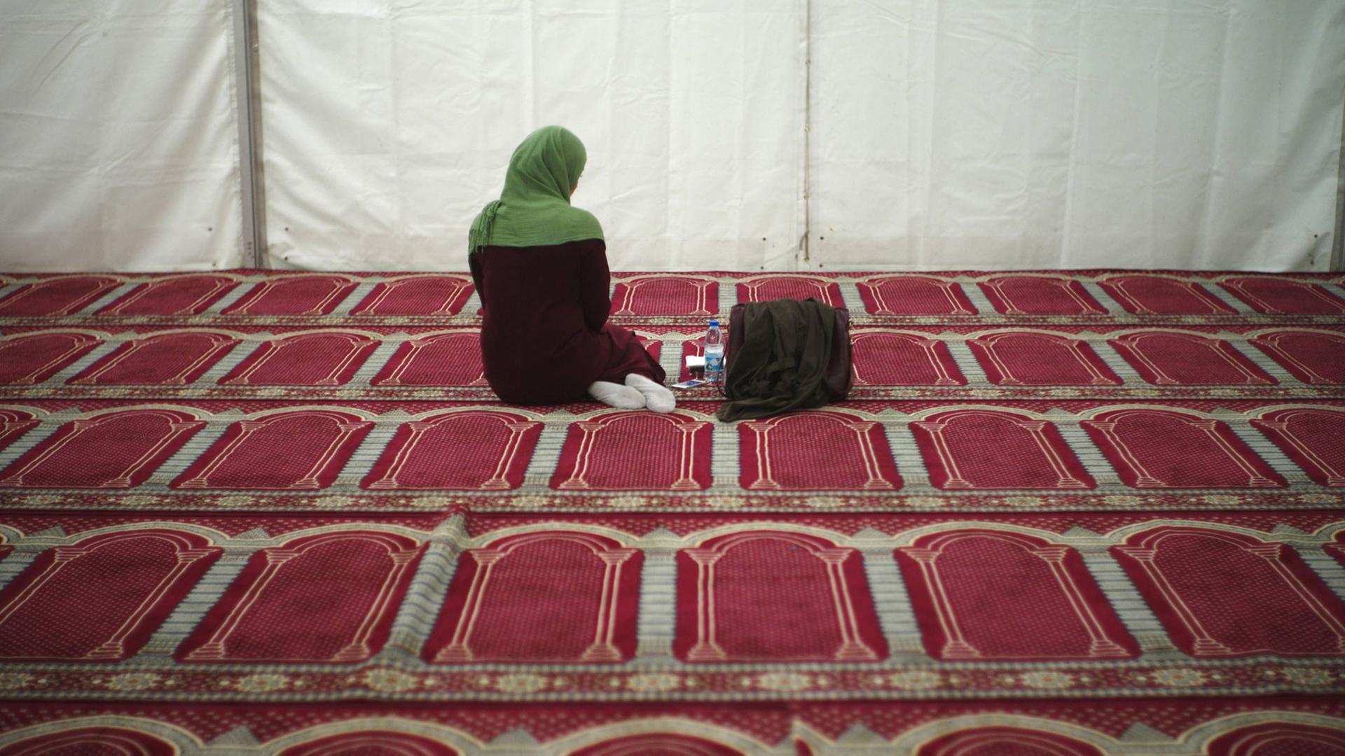Eine Besucherin ist während des Gebets in einem vorläufigen Zelt als Moschee zu sehen. Eine Besucherin ist während des Gebets in einem vorläufigen Zelt als Moschee zu sehen.