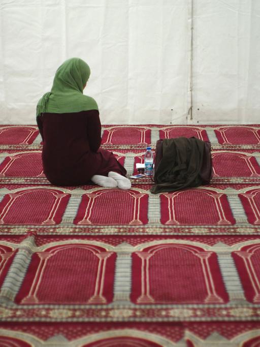 Eine Besucherin ist während des Gebets in einem vorläufigen Zelt als Moschee zu sehen.