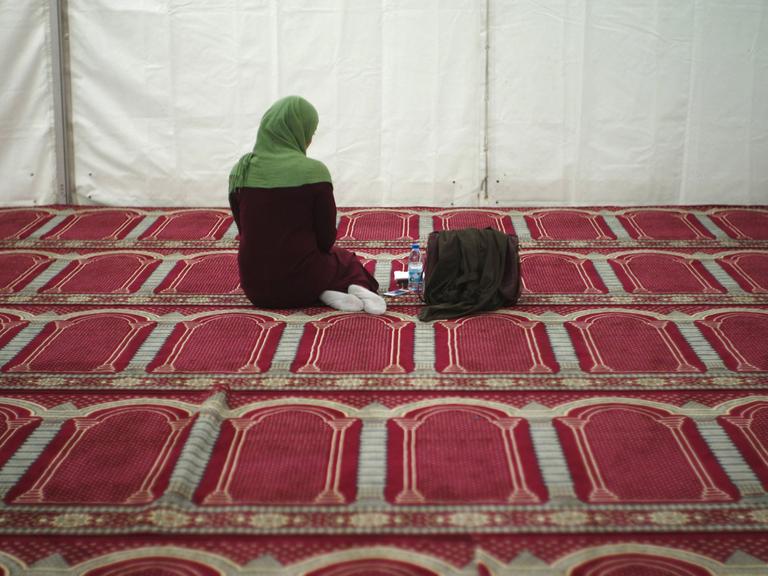 Eine Besucherin ist während des Gebets in einem vorläufigen Zelt als Moschee zu sehen.