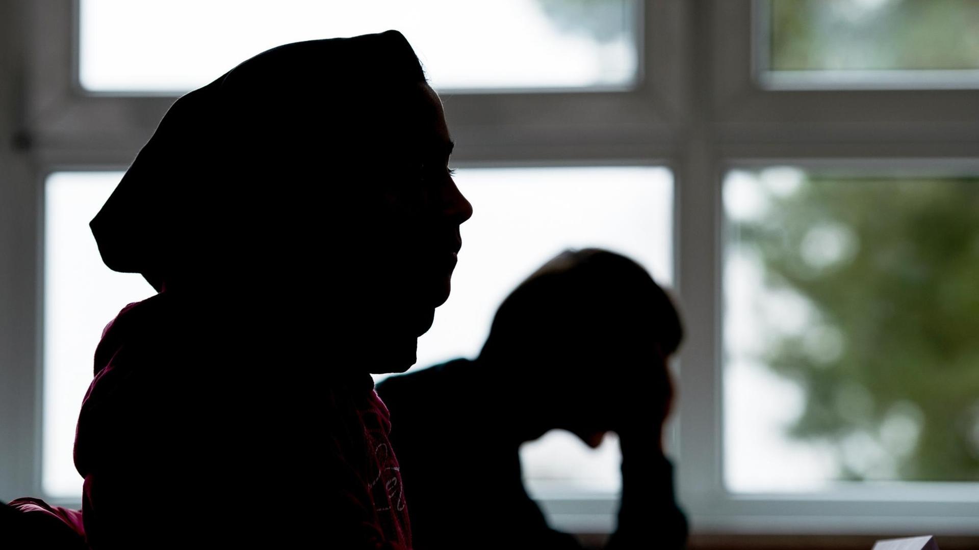Ein Flüchtlingsmädchen aus Afghanistan sitzt mit Kopftuch in einem Klassenraum der Maxim-Gorki-Oberschule in Bad Saarow (Brandenburg) und lernt Deutsch Ein Flüchtlingsmädchen aus Afghanistan sitzt mit Kopftuch in einem Klassenraum der Maxim-Gorki-Oberschule in Bad Saarow (Brandenburg) und lernt Deutsch