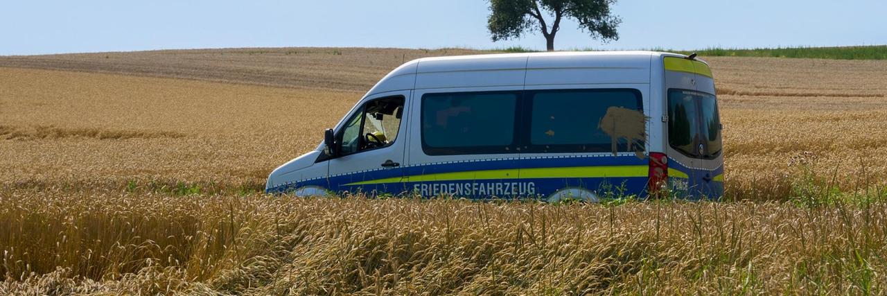 Ein Transporter mit der Aufschrift "Friedensfahrzeug" fährt am Rand des Katastrophengebiets in Ahrweiler.