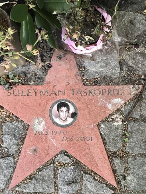 In der Hamburger Schützenstraße erinnert neben einem Gedenkstein auch ein Stern mit einem kleinen Porträtfoto an den Gemüsehändler Süleyman Tasköprü, der hier von den Rechtsterroristen des NSU erschossen wurde