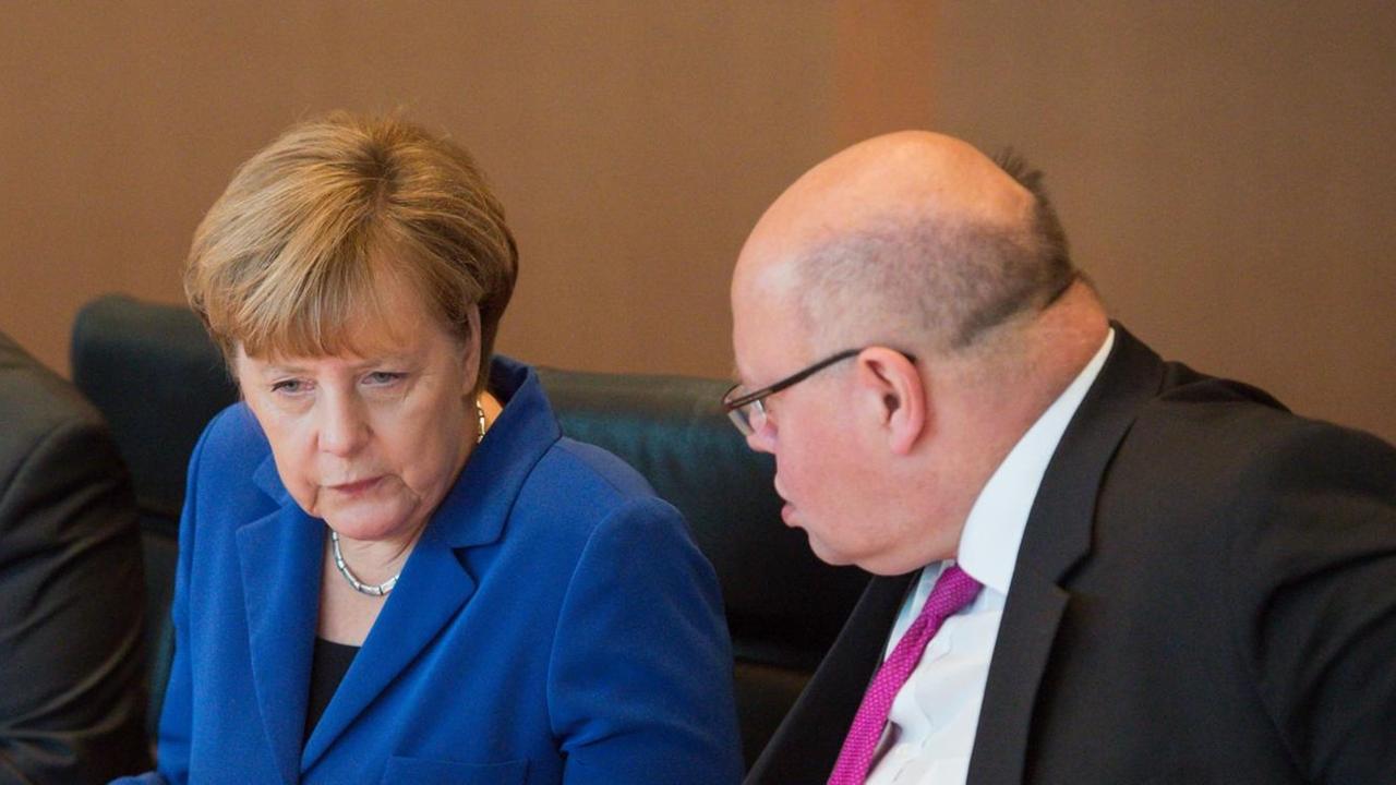 Bundeskanzlerin Angela Merkel (CDU) und Peter Altmaier (CDU), Chef des Bundeskanzleramtes, unterhalten sich am 07.10.2015 zu Beginn der Sitzung des Bundeskabinetts im Bundeskanzleramt in Berlin, links daneben sitzt Bundeswirtschaftsminister Sigmar Gabriel (SPD). Bundeskanzlerin Angela Merkel (CDU) und Peter Altmaier (CDU), Chef des Bundeskanzleramtes, unterhalten sich am 07.10.2015 zu Beginn der Sitzung des Bundeskabinetts im Bundeskanzleramt in Berlin, links daneben sitzt Bundeswirtschaftsminister Sigmar Gabriel (SPD).