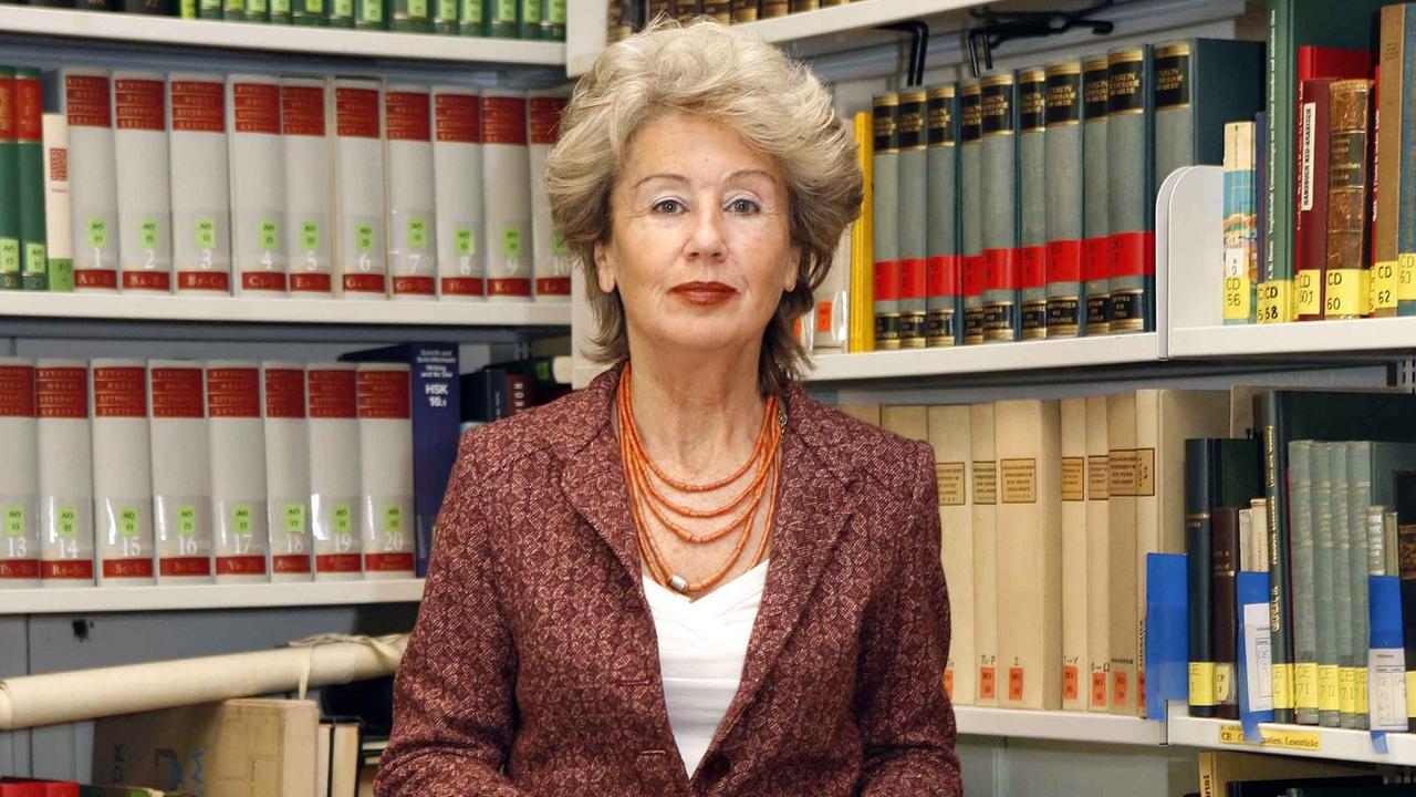 Die Preisträgerin Angelika Neuwirth steht in einer Bibliothek der FU Berlin vor dicht gefüllten Bücherregalen. Die Preisträgerin Angelika Neuwirth steht in einer Bibliothek der FU Berlin vor dicht gefüllten Bücherregalen.