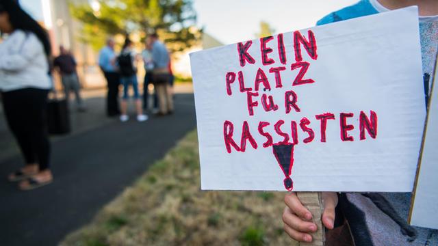 Ein Junge hält bei der Mahnwache in Wächtersbach ein Schild mit der Aufschrift "Kein Platz für Rassismus".