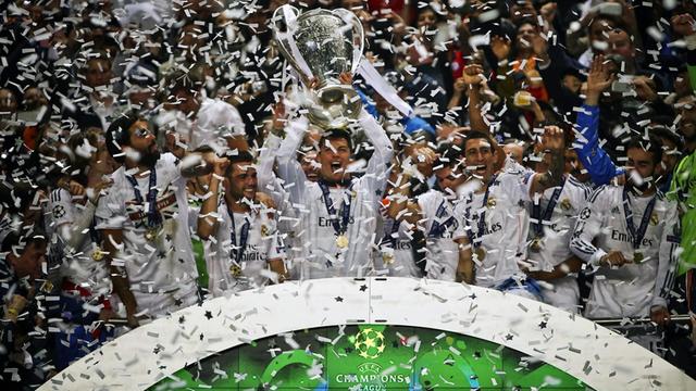 Ein Spieler stemmt den Champions-League-Pokal in die Luft.