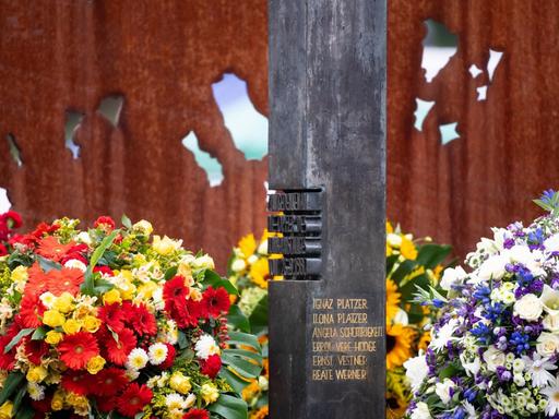 Eine von Blumen umkränzte Säule zeigt die Namen der Opfer des rechtsextremen Terroranschlags auf das Münchner Oktoberfest im September 1980.