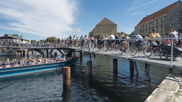Radfahrer auf einer neuen Fahrrad- und Fußgängerbrücke, Innenhafenbrücke, Butterfly 3-Wege-Brücke, im Hafen von Kopenhagen.