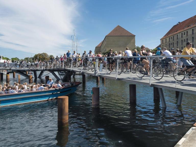 Radfahrer auf einer neuen Fahrrad- und Fußgängerbrücke, Innenhafenbrücke, Butterfly 3-Wege-Brücke, im Hafen von Kopenhagen.