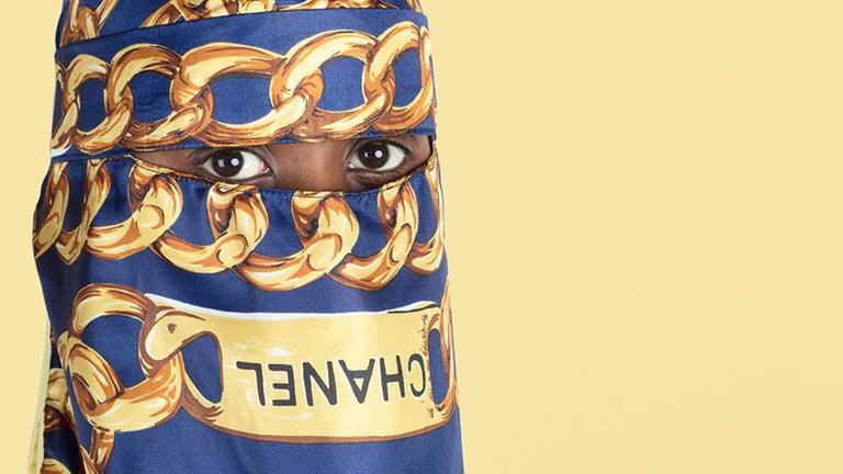 Eine Frau mit Chanel-Hidjab auf dem eine Kette zu sehen ist. Eine Frau mit Chanel-Hidjab auf dem eine Kette zu sehen ist.