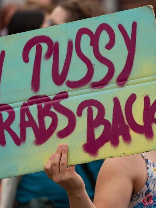 Protest gegen sexuelle Übergriffe: Eine Frau hält ein Plakat mit der Aufschrift "My pussy grabs back" hoch.