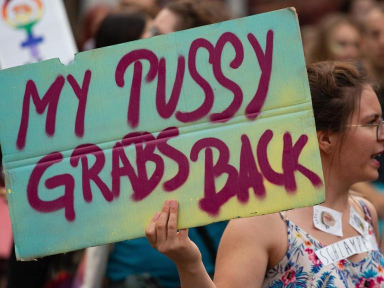 Protest gegen sexuelle Übergriffe: Eine Frau hält ein Plakat mit der Aufschrift "My pussy grabs back" hoch.