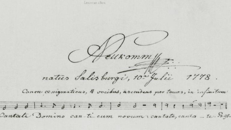 Eine geschwungene Unterschrift des Komponisten, der auch gleich eine Notenzeile dazu geschrieben hat.