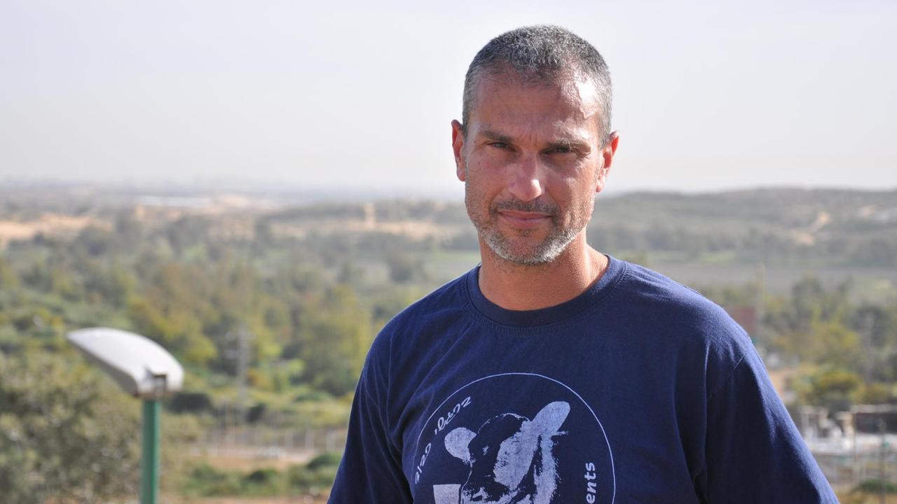 Gabo Altmark wohnt im Kibbutz Zikim unweit von Gaza. Er steht auf einem Dach, hinter ihm Wüste und Bäume.